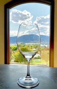 Close-up of wine glass on table against window