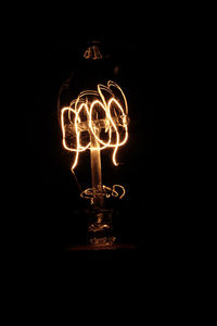 Close-up of illuminated lighting equipment against black background