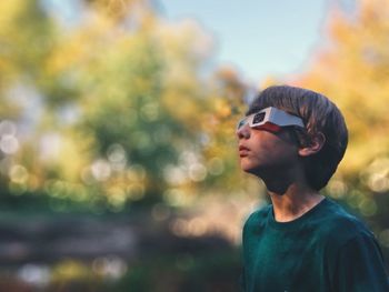 Boy wearing 3d glasses while standing outdoors