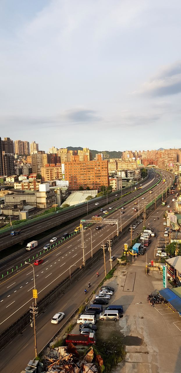 transportation, mode of transportation, city, motor vehicle, car, land vehicle, high angle view, building exterior, architecture, sky, street, built structure, road, cityscape, nature, traffic, cloud - sky, day, no people, city life, outdoors, multiple lane highway