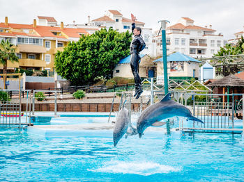 Man jumping in swimming pool against sky