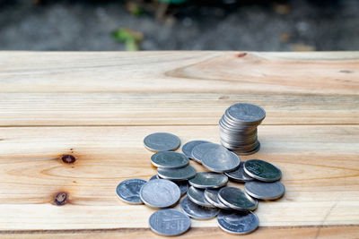 High angle view of coins on wooden table