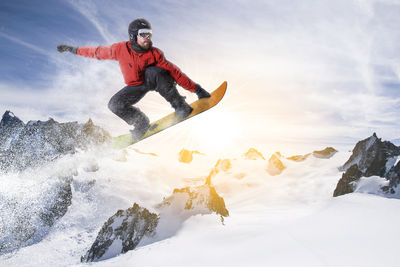 Low angle view of man jumping on snow