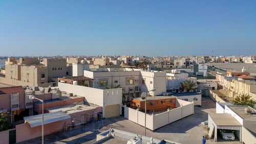 High angle view of buildings against clear blue sky