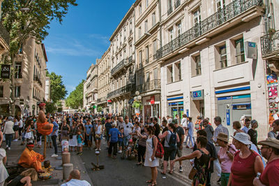 People on street against buildings in city