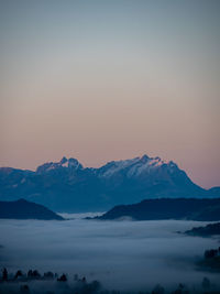 Scenic view of snowcapped mountains against sky during sunset