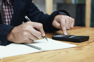 Midsection of man working on table