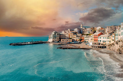 Scenic view of sea by buildings against sky in city