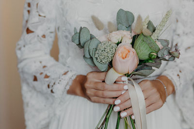 Midsection of woman holding flower bouquet