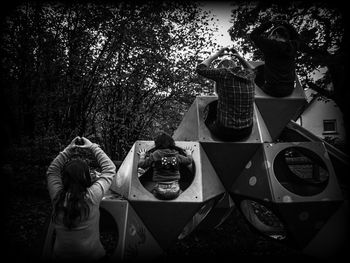 Rear view of friends standing against trees