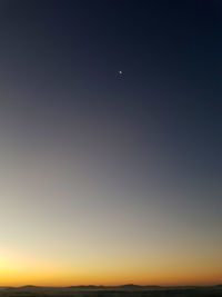 Low angle view of silhouette moon against clear sky at sunset