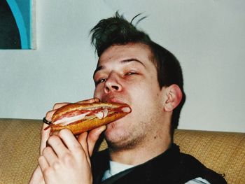 Portrait of man eating food at home