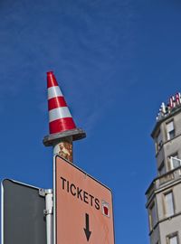 Low angle view of sign by building against sky