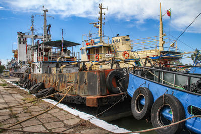 Boats moored on shore against sky