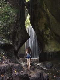 Woman standing on rock in forest