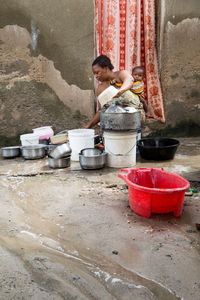 Woman with children washing utensils at home