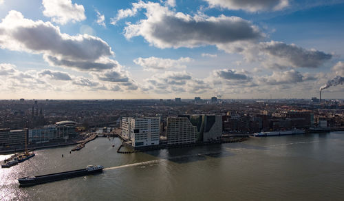 Scenic view of river by buildings against sky