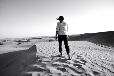 Full length of man standing on beach against clear sky