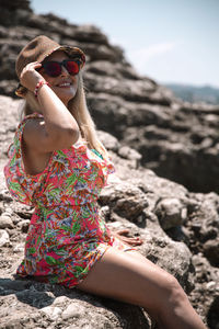 Woman wearing sunglasses on rock