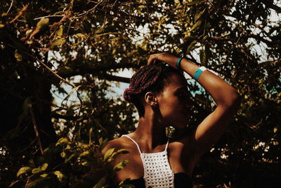 Young woman standing amidst tree