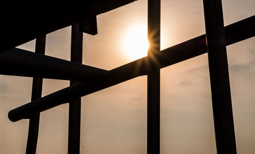 Close-up of railing against sky during sunset