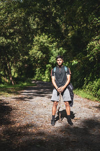 An adventurer man, with a stick in his hand is exploring a mystery jungle