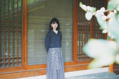 Portrait of woman standing against plants