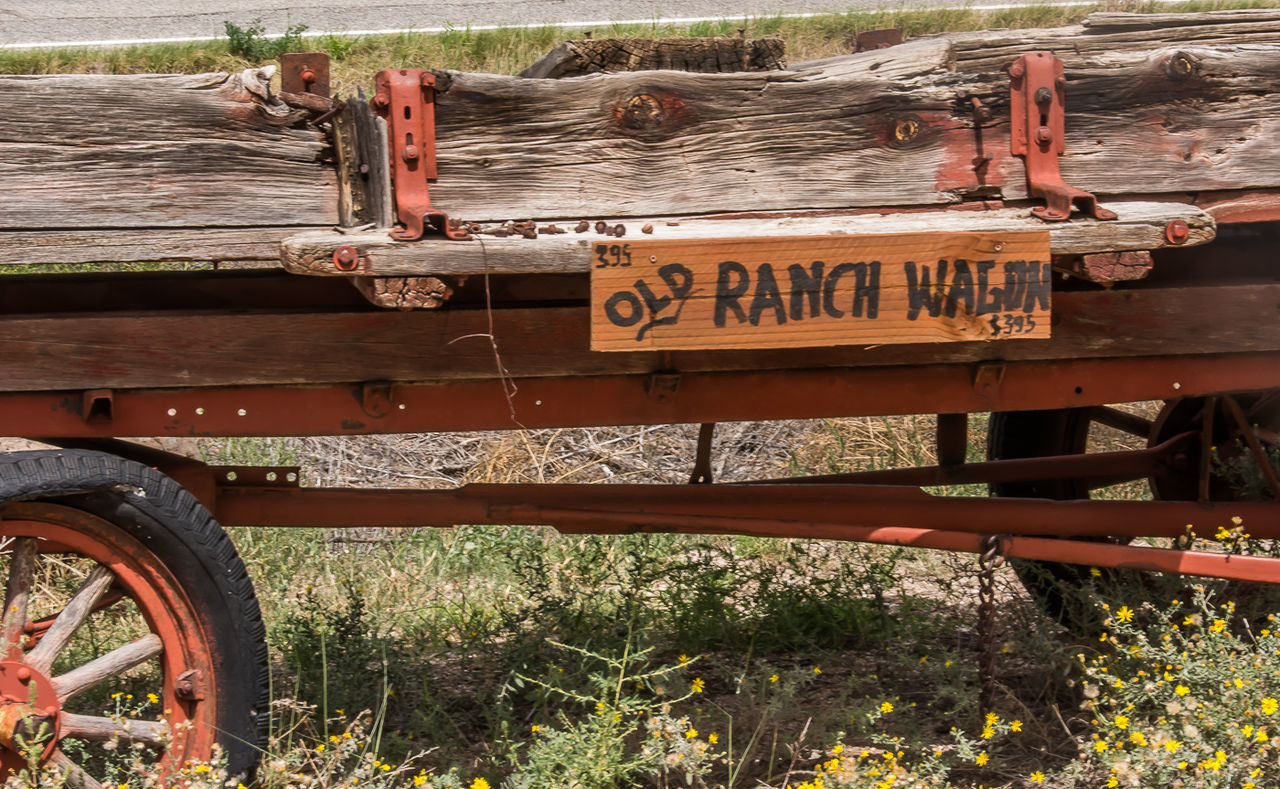 VIEW OF RUSTY SIGN BY WOODEN POST