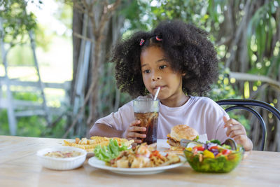 Portrait of cute girl sitting on table