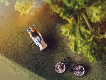 High angle view of male figurine sitting on lounge chair at table