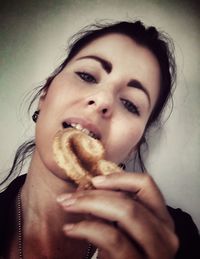 Close-up portrait of a young woman against wall