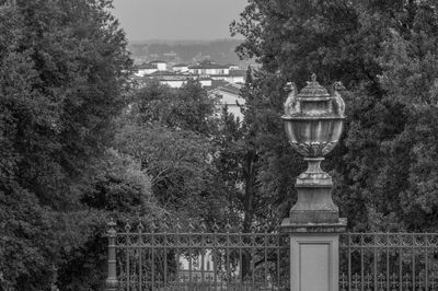 Bridge in park by buildings against sky