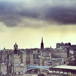 View of cityscape against cloudy sky