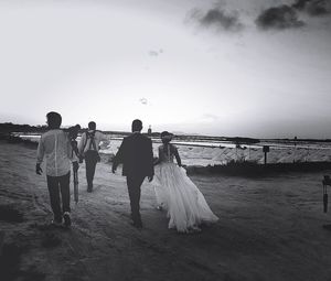 Rear view of couple walking on beach