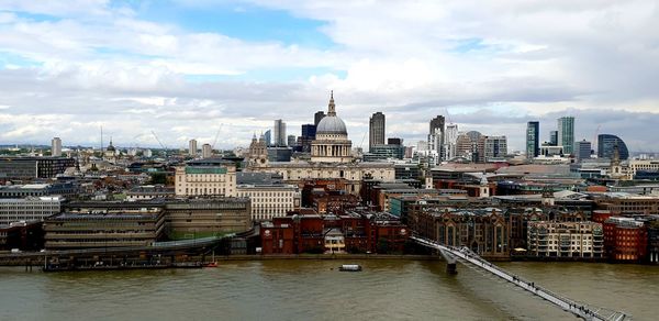 Buildings in city against cloudy sky