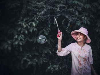 Full length of smiling girl standing against water