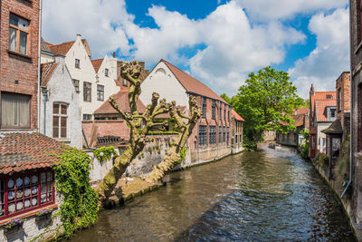 Canal amidst buildings against sky