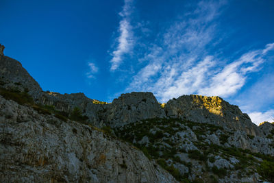 Low angle view of mountain against blue sky