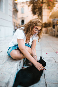 Full length of woman sitting outdoors