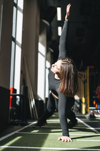 Young brunette woman training her muscles in fitness club gym