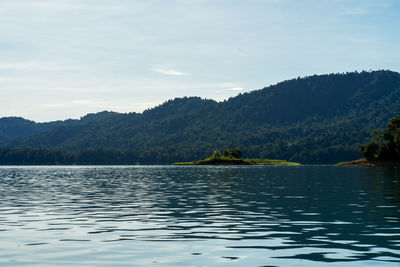 Scenic view of lake by mountain against sky