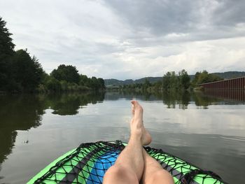 Low section of man relaxing on lake