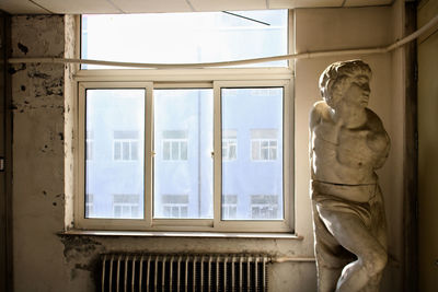 Low angle view of woman looking through window