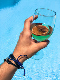 Midsection of woman holding ice cream in swimming pool