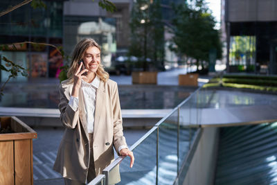 Portrait of young woman standing in city