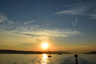 Boats in calm sea at sunset