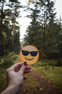 Close-up of hand holding emoji outdoors