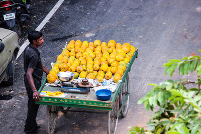 Vendor selling papayas on cart at street