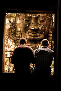 Close-up of people sitting on wall