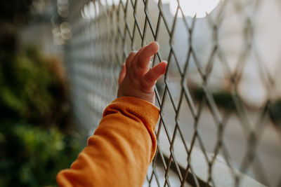 Close-up of hand on chainlink fence